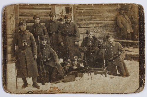 Fotografia dziewięciu żołnierzy w zimowych mundurach Wojska Polskiego, przy lekkim karabinie maszyno